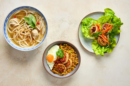 Three chicken and edamame bite meal ideas: noodle soup, rice bowl with egg, and lettuce wraps with vegetables on plates.