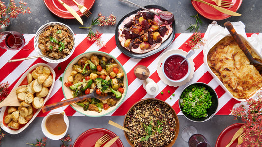 Festive Christmas table with Dinner Ladies roast vegetables, gratin, salad, stuffing, cranberry sauce, and dessert.