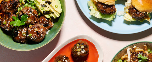 Japanese beef bites served with sesame seeds, greens, and dipping sauce.