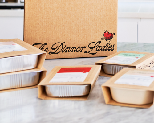 The Dinner Ladies packaged meals on a kitchen bench, ready to enjoy.