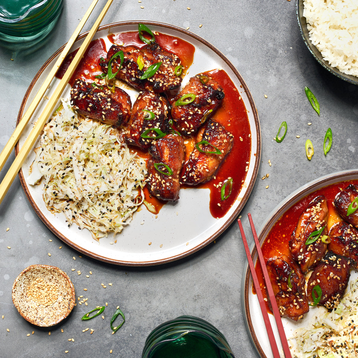 Teriyaki chicken served with sesame slaw and steamed rice, topped with spring onio