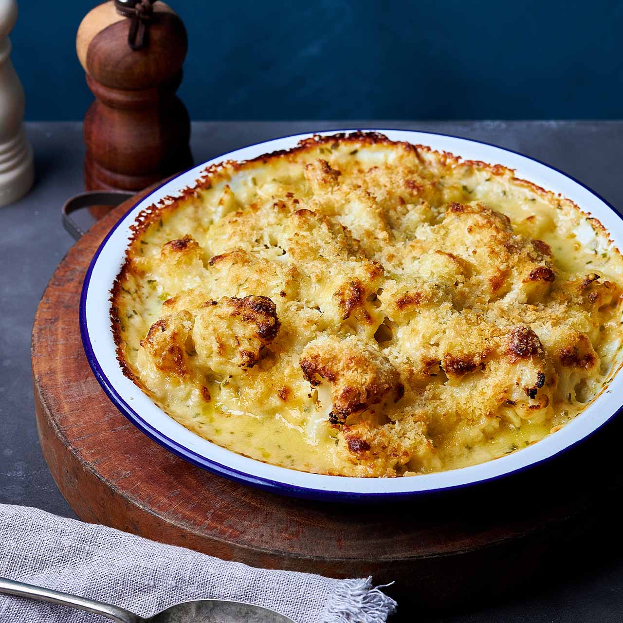 Golden cauliflower and smoked cheese gratin baked with a crispy topping of cheddar, Parmesan and breadcrumbs.