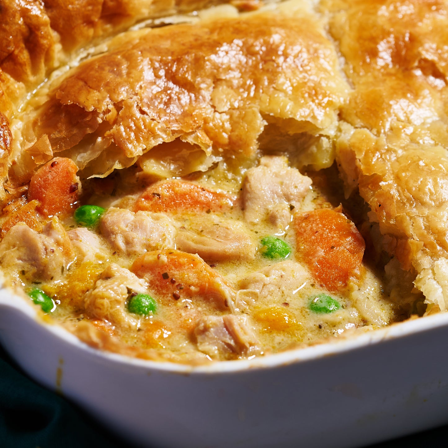 Close up of Chicken and Roast Vegetable Pie filling with free-range chicken, carrots, peas and creamy tarragon sauce.