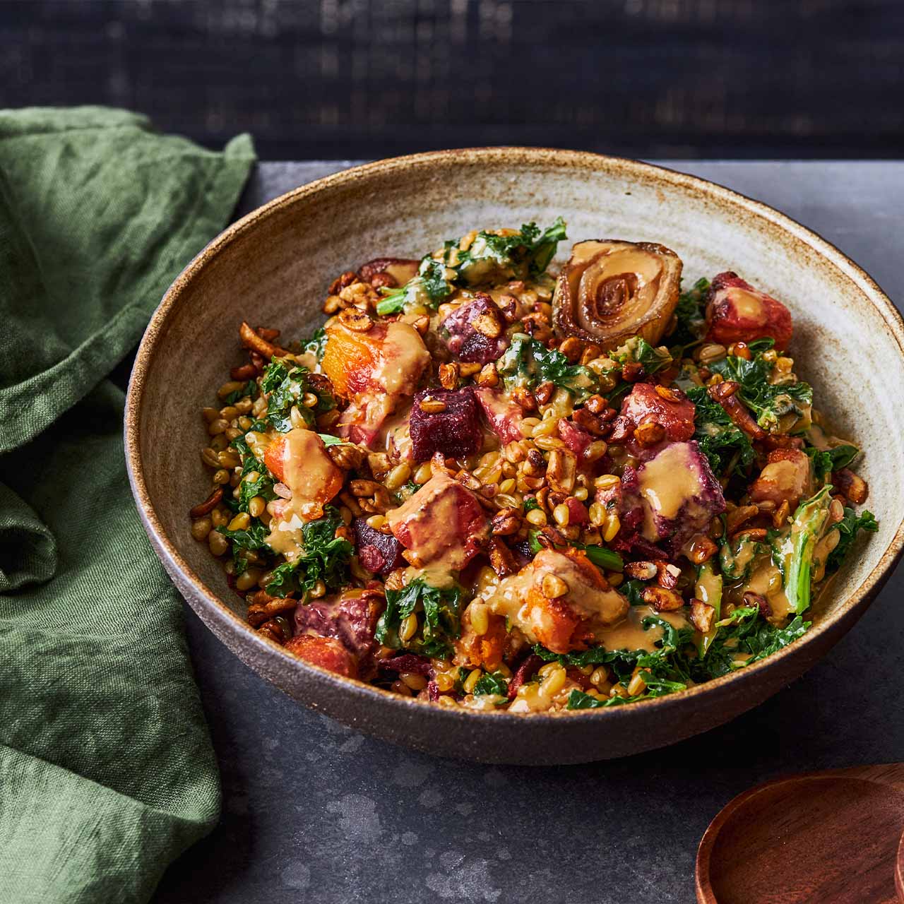 Bowl of Roast Vegetables with Miso, Cashews and Freekeh, with kale, beetroot, pumpkin & tamari cashews, drizzled in miso-tahini dressing.