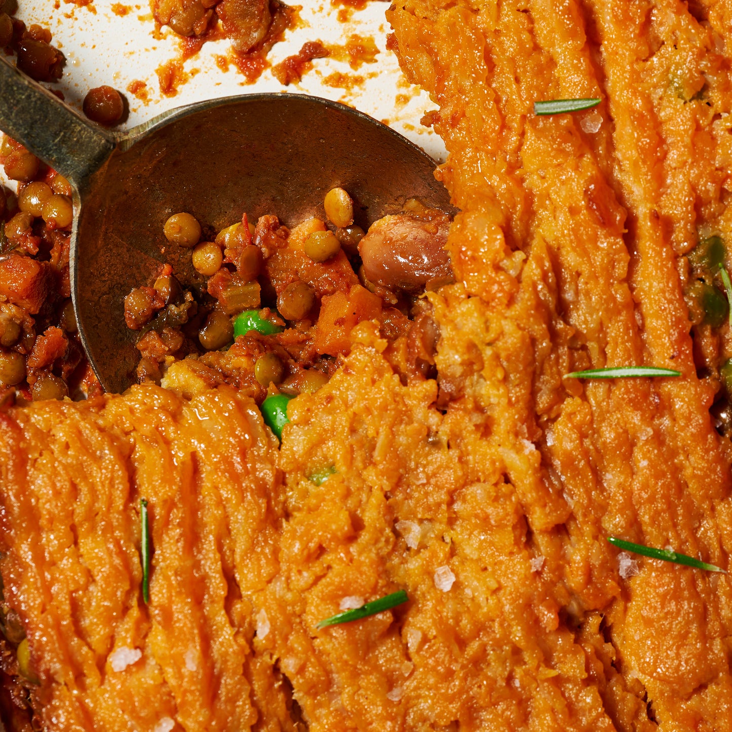 Close-up of the lentil and borlotti bean filling with peas and carrots under the sweet potato mash topping.