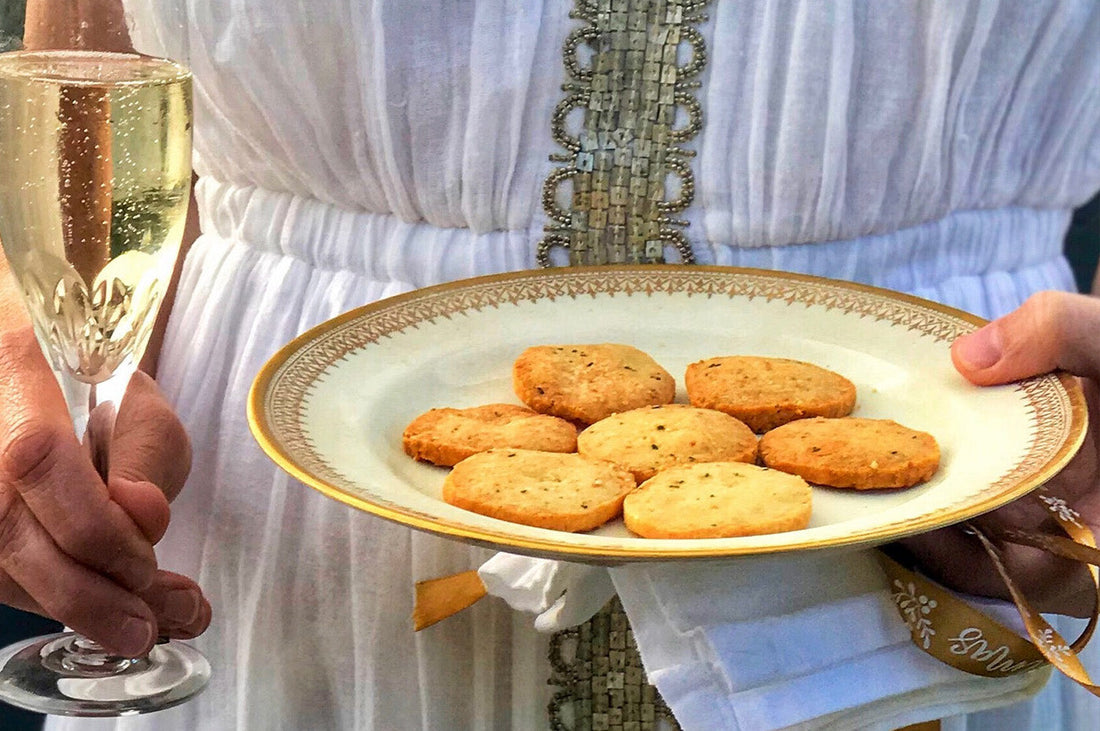 plate of cheese and rosemary biscuits with a glass of sparkling wine, festive and ready to serve.