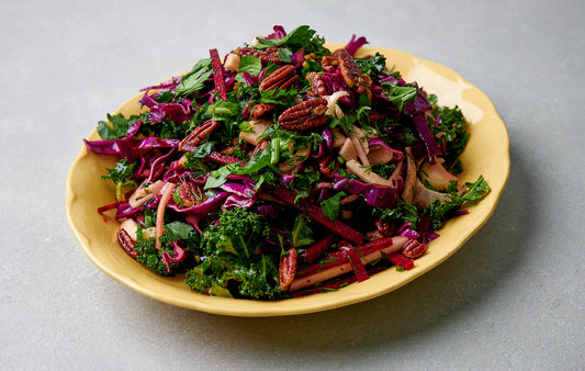 Plate of Christmas slaw with kale, red cabbage, pecans, and herbs.