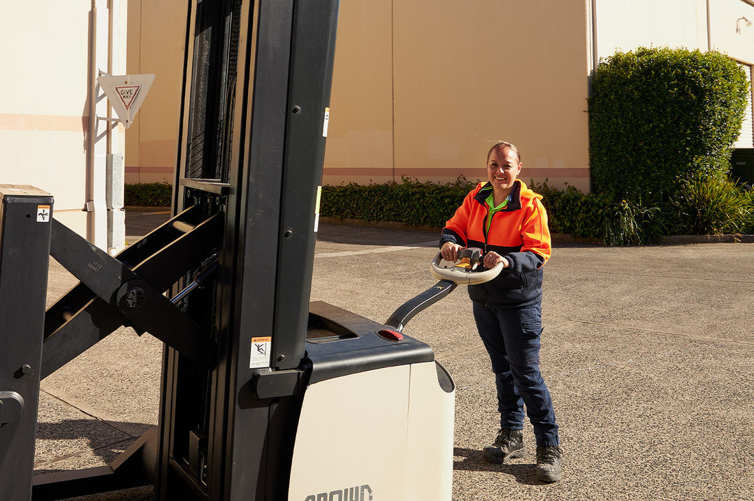 Aroha, Dinner Ladies freezer supervisor, smiling while operating a forklift outdoors.