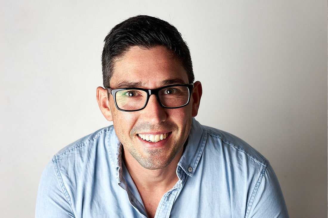 Ian, Customer Experience Manager at Dinner Ladies, smiling in a blue shirt against a plain background.