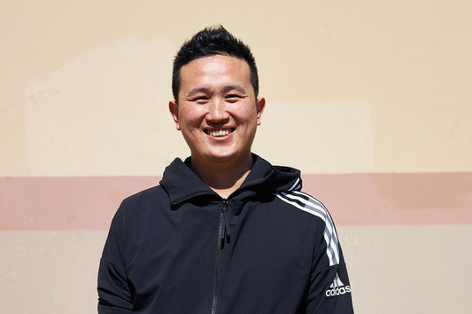 Wilson, Dinner Ladies warehouse manager, smiling outdoors in a black Adidas jacket.