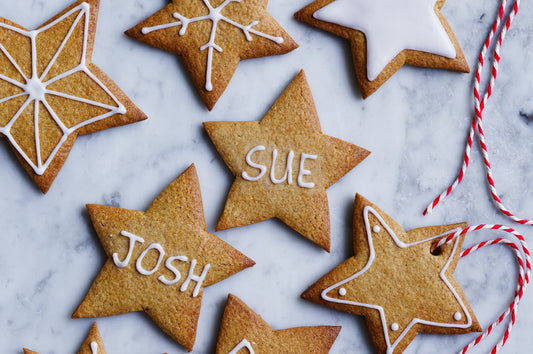 Star-shaped Christmas cookies with icing, some decorated with names.
