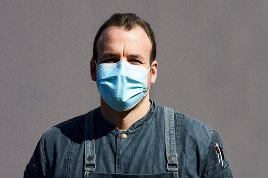Head chef in mask showing The Dinner Ladies’ COVID safety measures to protect staff and customers.