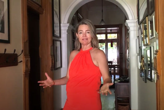 Katherine from The Dinner Ladies standing in a hallway, wearing a red halter dress, sharing her 28 Day Body Blitz story.