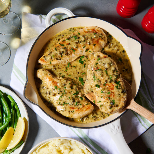 Chicken scallopine in a creamy green peppercorn and Dijon sauce, in a skillet with mashed potato and green beans on the side