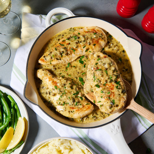 Chicken scallopine in a creamy green peppercorn and Dijon sauce, in a skillet with mashed potato and green beans on the side
