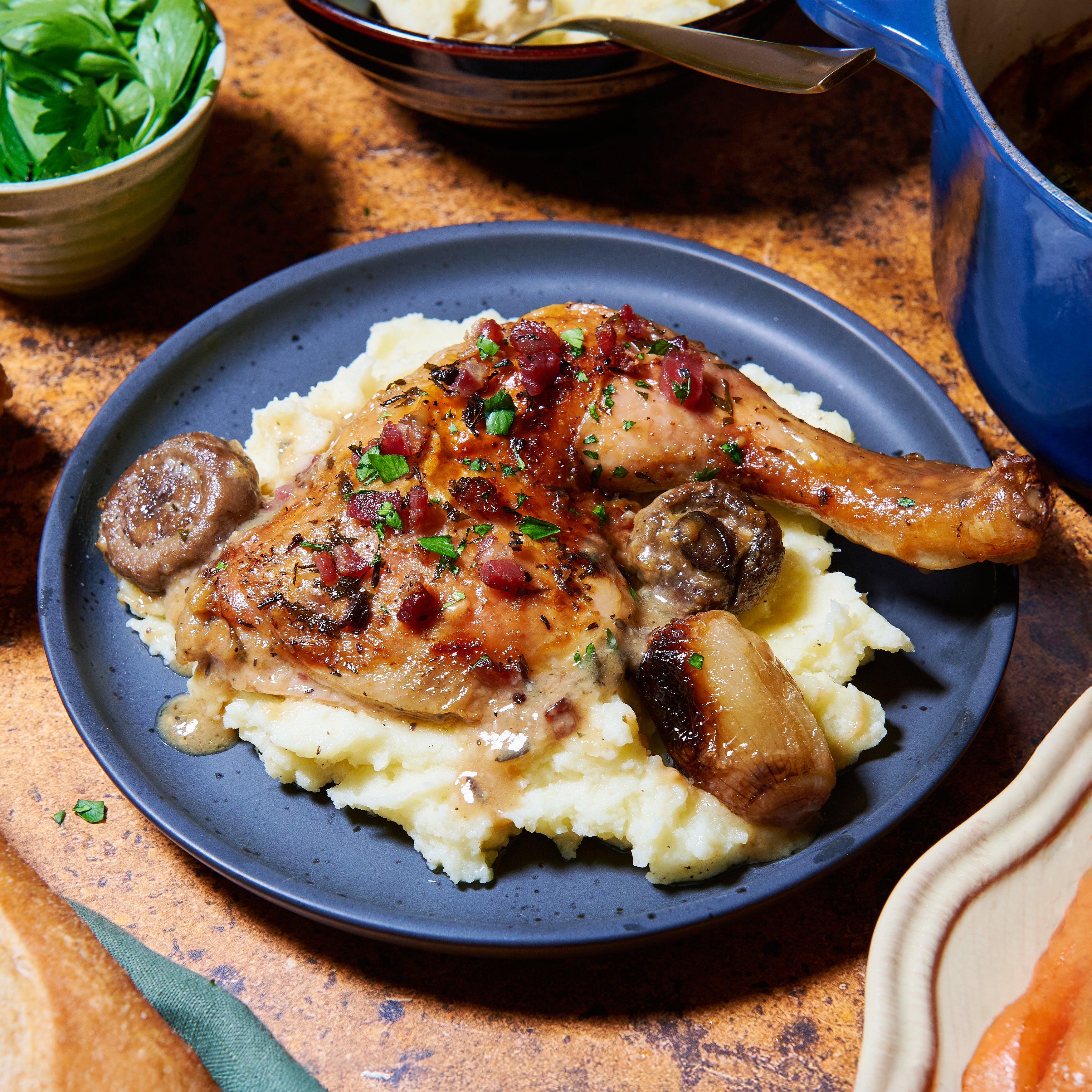 Coq a vin blanc with mash potato on a plate