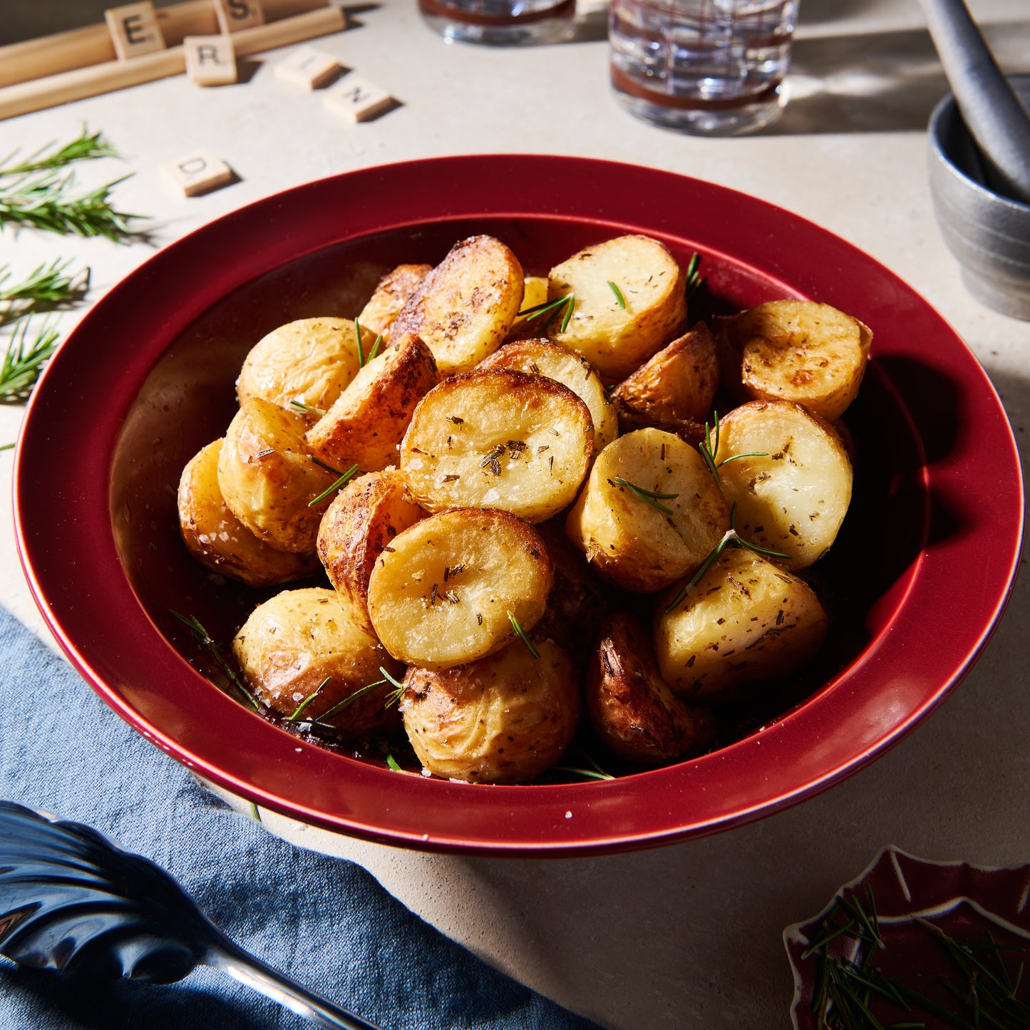 Duck fat potatoes with garlic and rosemary in a red bowl