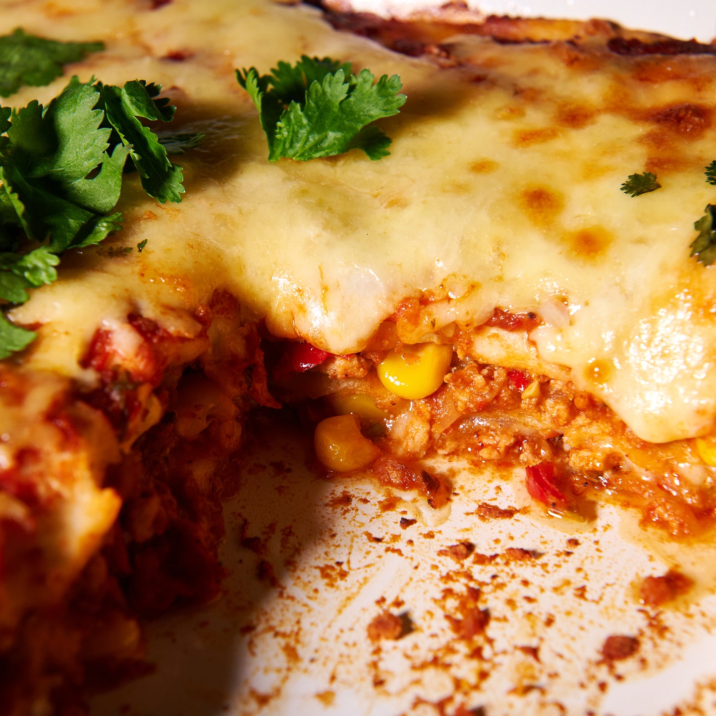 Layered chicken enchiladas with sweet corn and coriander