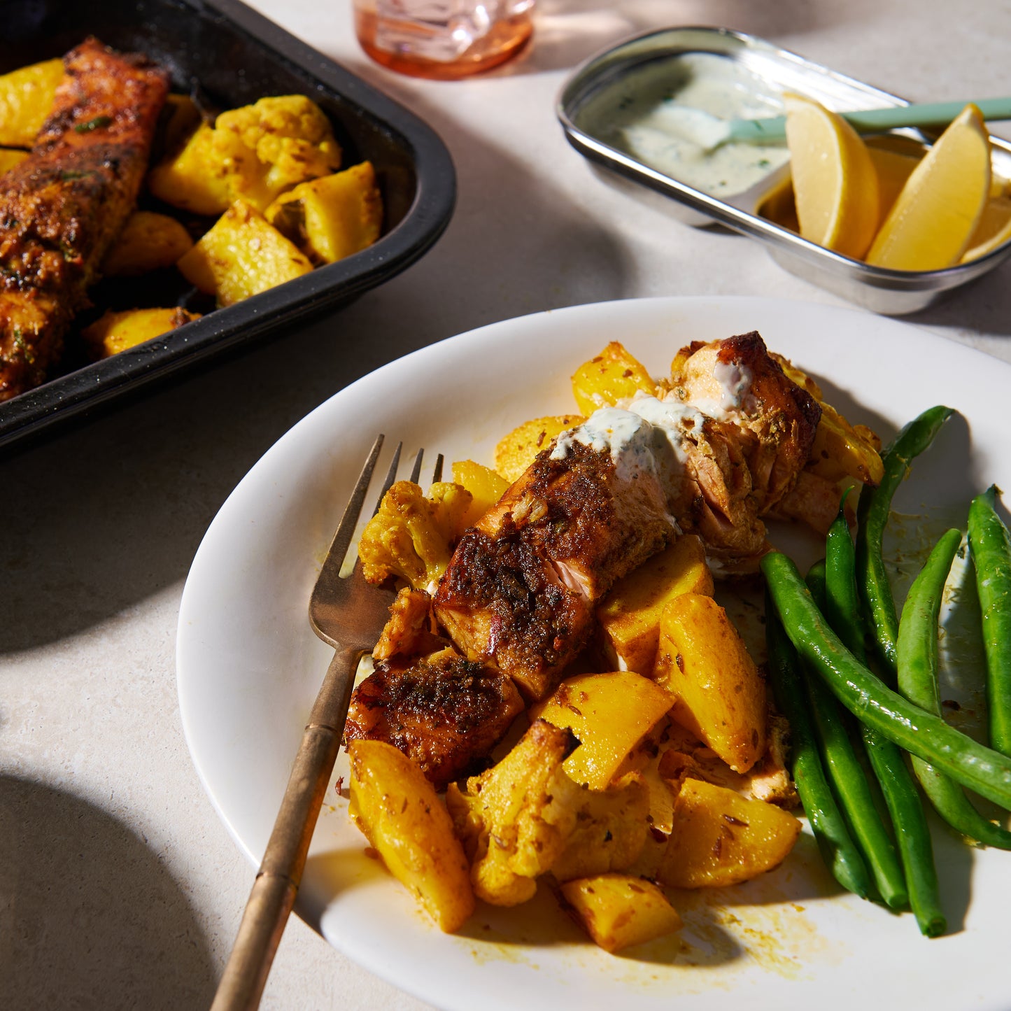 Salmon tikka tray bake with turmeric spiced potatoes and cauliflower on a plate
