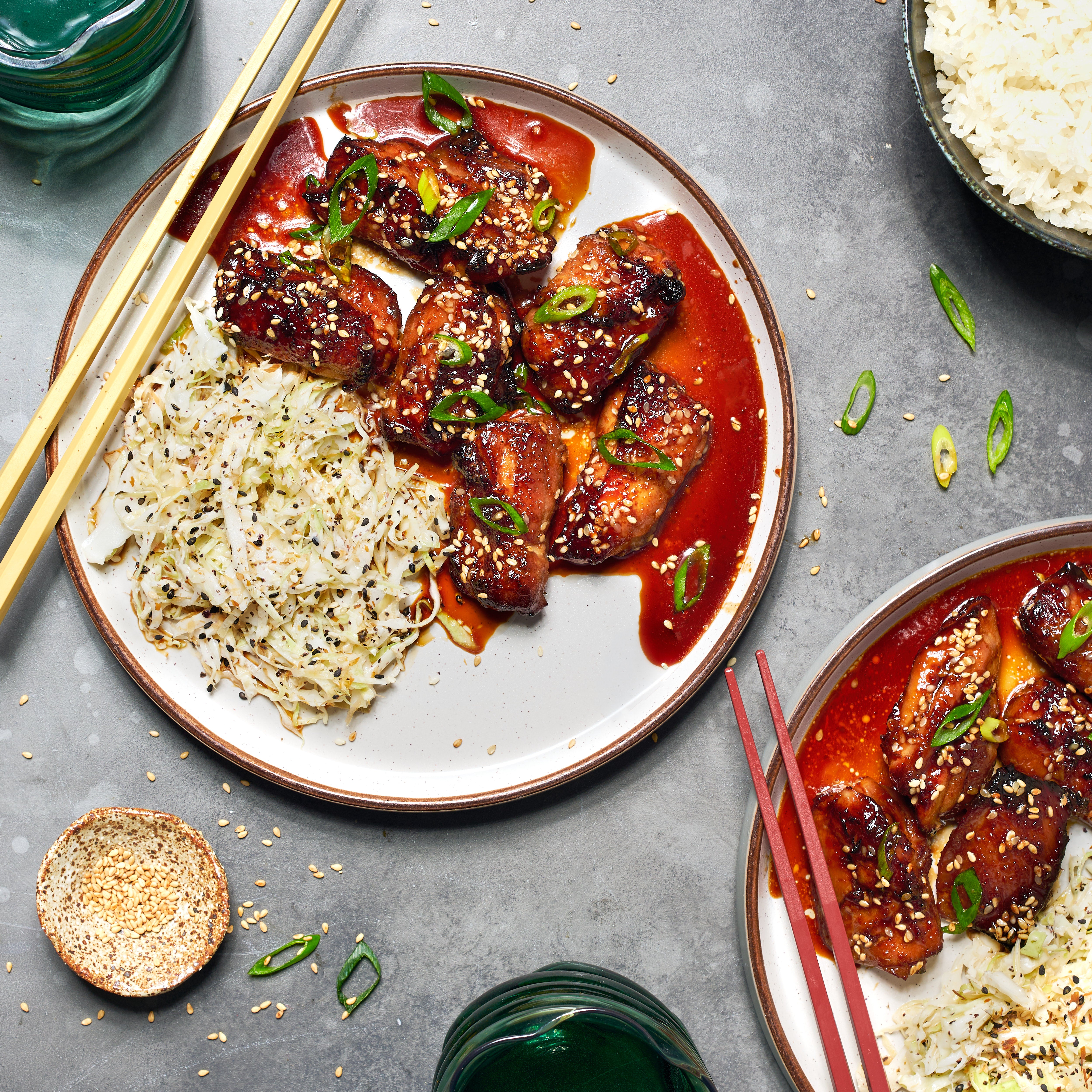 Teriyaki chicken served with sesame slaw and steamed rice, topped with spring onio