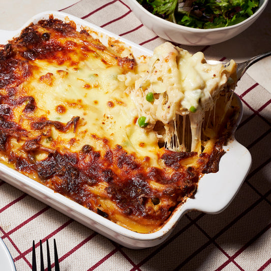 A bubbling baked pasta al forno with golden mozzarella on top, filled with smoked chicken, peas, and creamy sauce.